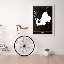Lade das Bild in den Galerie-Viewer, Chiemsee Dark Poster - Minimal - Vorschau in einem hellen Zimmer mit Fahrrad an Wand angelehnt