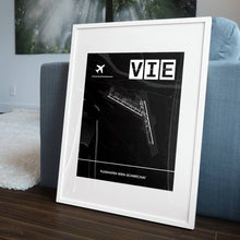 Lade das Bild in den Galerie-Viewer, Flughafen Wien-Schwechat (VIE / LOWW) Dark Poster - Minimal - Vorschau in einem Wohnzimmer am Boden aufgestellt und auf der Couch angelehnt