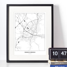 Lade das Bild in den Galerie-Viewer, Freiburg im Breisgau Light Poster - Minimal - Vorschau vor weißer Wand zusammen mit Dekoartikeln
