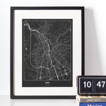 Lade das Bild in den Galerie-Viewer, Graz Dark Poster - Minimal - Vorschau vor weißer Wand zusammen mit Dekoartikeln