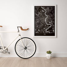 Lade das Bild in den Galerie-Viewer, Köln Dark Poster - Minimal - Vorschau in einem hellen Zimmer mit Fahrrad an Wand angelehnt