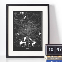 Lade das Bild in den Galerie-Viewer, Leipzig Dark Poster - Minimal - Vorschau vor weißer Wand zusammen mit Dekoartikeln