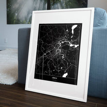 Lade das Bild in den Galerie-Viewer, Lübeck Dark Poster - Minimal - Vorschau in einem Wohnzimmer am Boden aufgestellt und auf der Couch angelehnt