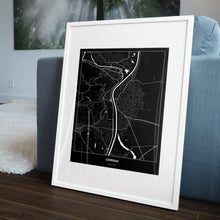 Lade das Bild in den Galerie-Viewer, Lustenau Dark Poster - Minimal - Vorschau in einem Wohnzimmer am Boden aufgestellt und auf der Couch angelehnt