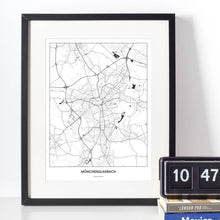 Lade das Bild in den Galerie-Viewer, Mönchengladbach Light Poster - Minimal - Vorschau vor weißer Wand zusammen mit Dekoartikeln