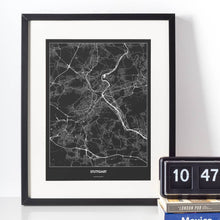 Lade das Bild in den Galerie-Viewer, Stuttgart Dark Poster - Minimal - Vorschau vor weißer Wand zusammen mit Dekoartikeln