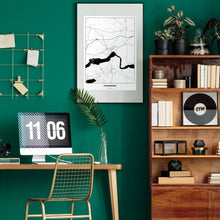 Lade das Bild in den Galerie-Viewer, Völkermarkt Light Poster - Minimal - Vorschau über Schreibtisch in einem Zimmer mit grüner Wand und Holzmöbel
