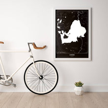 Lade das Bild in den Galerie-Viewer, Chiemsee Dark Poster - Minimal - Vorschau in einem hellen Zimmer mit Fahrrad an Wand angelehnt
