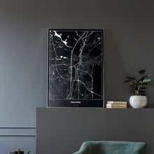 Lade das Bild in den Galerie-Viewer, Erlangen Dark Poster - Minimal - Vorschau in einem eleganten Zimmer mit Sessel und grauer Wand
