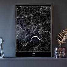 Lade das Bild in den Galerie-Viewer, Essen Dark Poster - Minimal - Vorschau neben Dekoartikeln vor dunkelgrauer Wand
