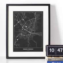 Lade das Bild in den Galerie-Viewer, Freiburg im Breisgau Dark Poster - Minimal - Vorschau vor weißer Wand zusammen mit Dekoartikeln
