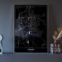 Lade das Bild in den Galerie-Viewer, Göttingen Dark Poster - Minimal - Vorschau neben Dekoartikeln vor dunkelgrauer Wand

