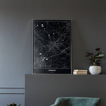 Lade das Bild in den Galerie-Viewer, Gütersloh Dark Poster - Minimal - Vorschau in einem eleganten Zimmer mit Sessel und grauer Wand
