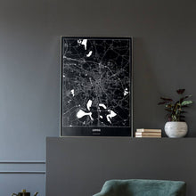 Lade das Bild in den Galerie-Viewer, Leipzig Dark Poster - Minimal - Vorschau in einem eleganten Zimmer mit Sessel und grauer Wand
