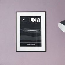 Lade das Bild in den Galerie-Viewer, London City Airport (Flughafen LCY / EGLC) Dark Poster - Minimal - Vorschau vor einer Wand in Pastelrosa
