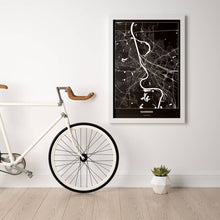 Lade das Bild in den Galerie-Viewer, Mannheim Dark Poster - Minimal - Vorschau in einem hellen Zimmer mit Fahrrad an Wand angelehnt
