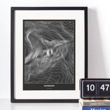 Lade das Bild in den Galerie-Viewer, Matterhorn Dark Poster - Minimal - Vorschau vor weißer Wand zusammen mit Dekoartikeln

