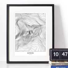 Lade das Bild in den Galerie-Viewer, Matterhorn Light Poster - Minimal - Vorschau vor weißer Wand zusammen mit Dekoartikeln
