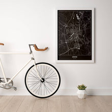 Lade das Bild in den Galerie-Viewer, Münster Dark Poster - Minimal - Vorschau in einem hellen Zimmer mit Fahrrad an Wand angelehnt
