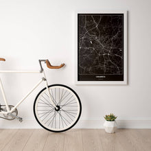 Lade das Bild in den Galerie-Viewer, Osnabrück Dark Poster - Minimal - Vorschau in einem hellen Zimmer mit Fahrrad an Wand angelehnt
