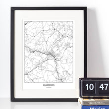 Lade das Bild in den Galerie-Viewer, Saarbrücken Light Poster - Minimal - Vorschau vor weißer Wand zusammen mit Dekoartikeln

