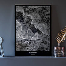 Lade das Bild in den Galerie-Viewer, Schneeberg Dark Poster - Minimal - Vorschau neben Dekoartikeln vor dunkelgrauer Wand

