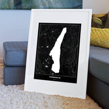 Lade das Bild in den Galerie-Viewer, Starnberger See Dark Poster - Minimal - Vorschau am Boden auf Couch angelehnt in einem Wohnzimmer
