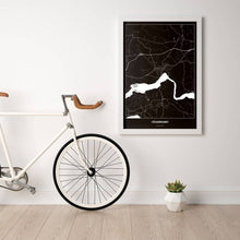 Lade das Bild in den Galerie-Viewer, Völkermarkt Dark Poster - Minimal - Vorschau in einem hellen Zimmer mit Fahrrad an Wand angelehnt
